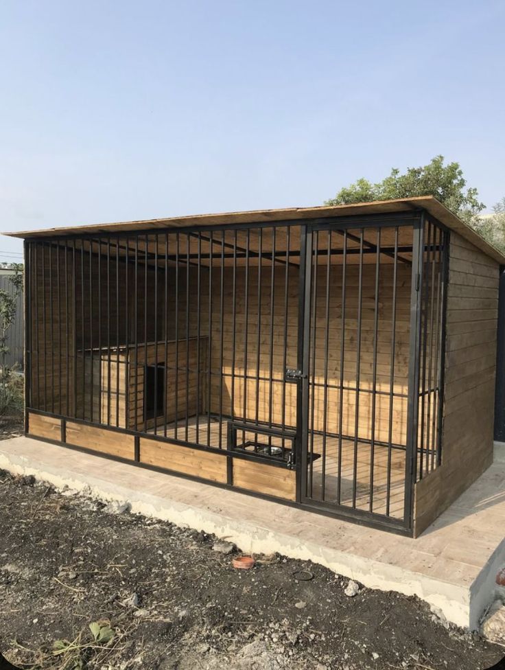 a dog kennel in the middle of a dirt field