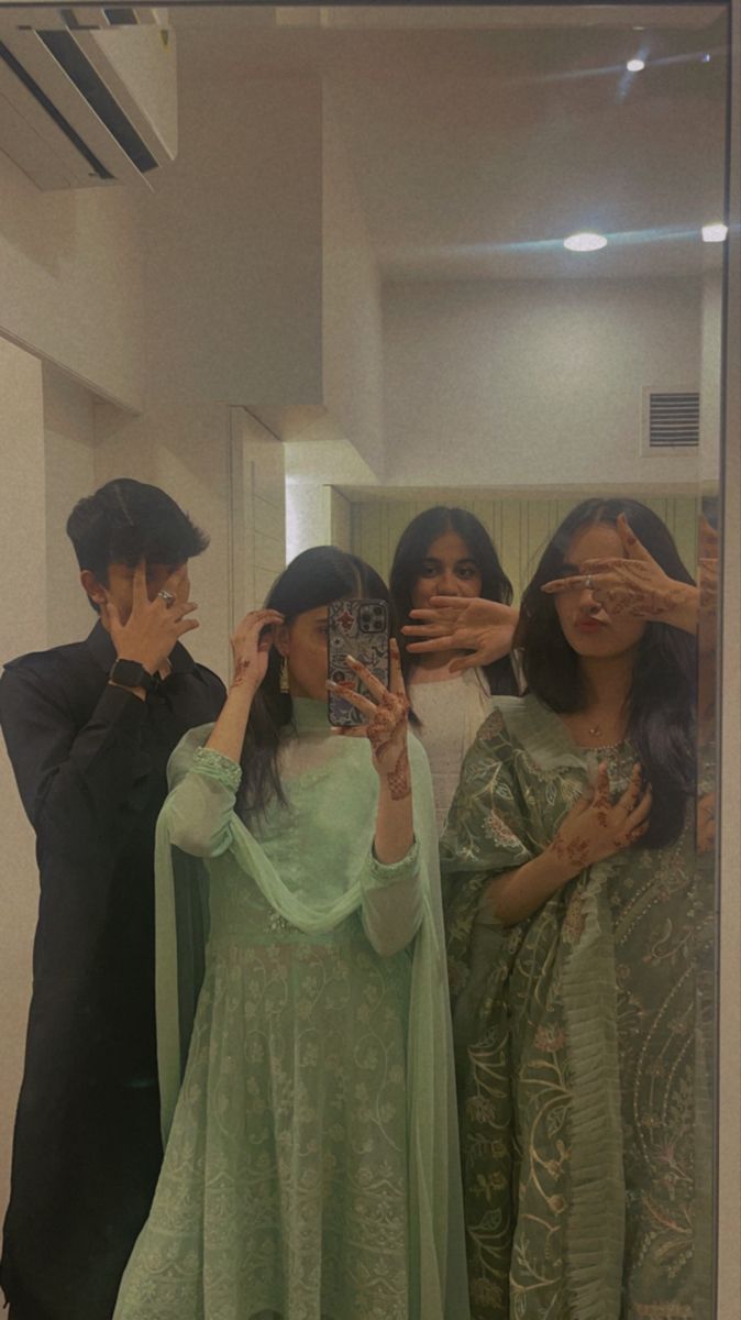 three people taking a selfie in front of a mirror with the reflection of them