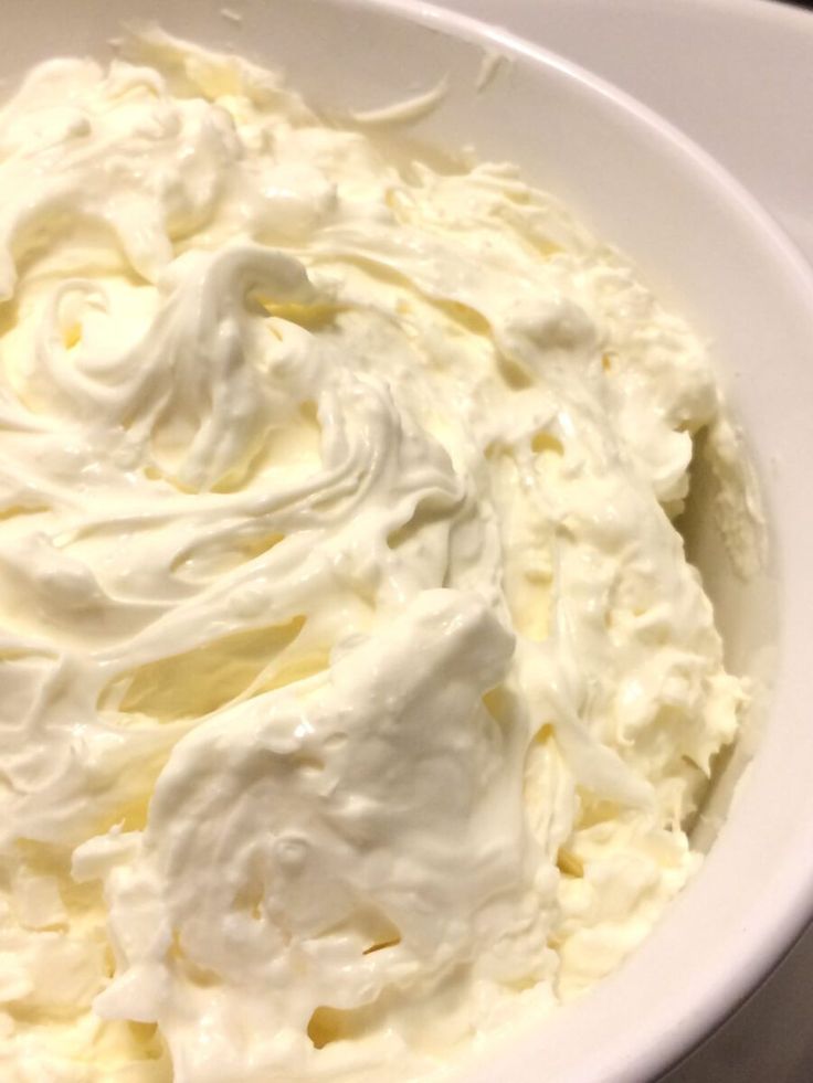 a white bowl filled with whipped cream on top of a table