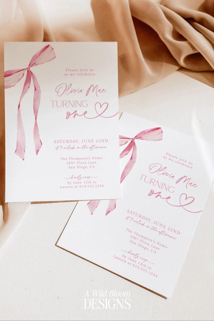 two wedding cards with pink ribbons on them