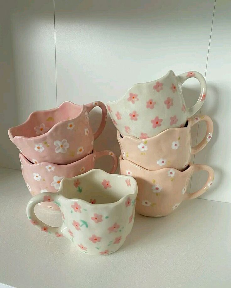 five cups are stacked on top of each other in the shape of hearts and flowers