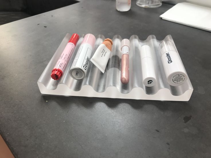 an assortment of lipstick and lip balm tubes on a counter top with one tube in the middle