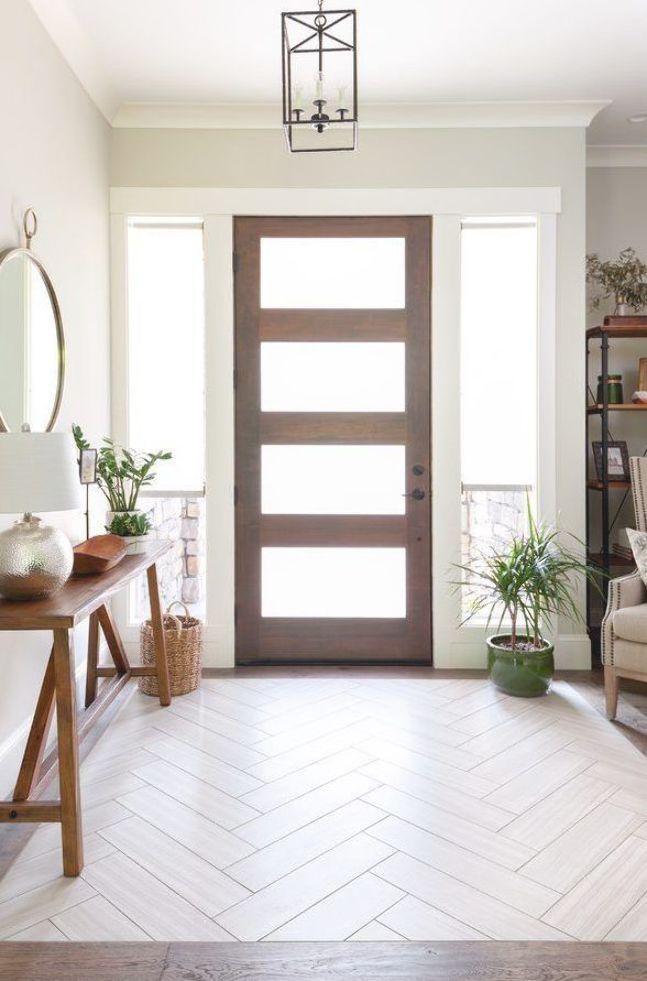 a white room with a wooden door and potted plants