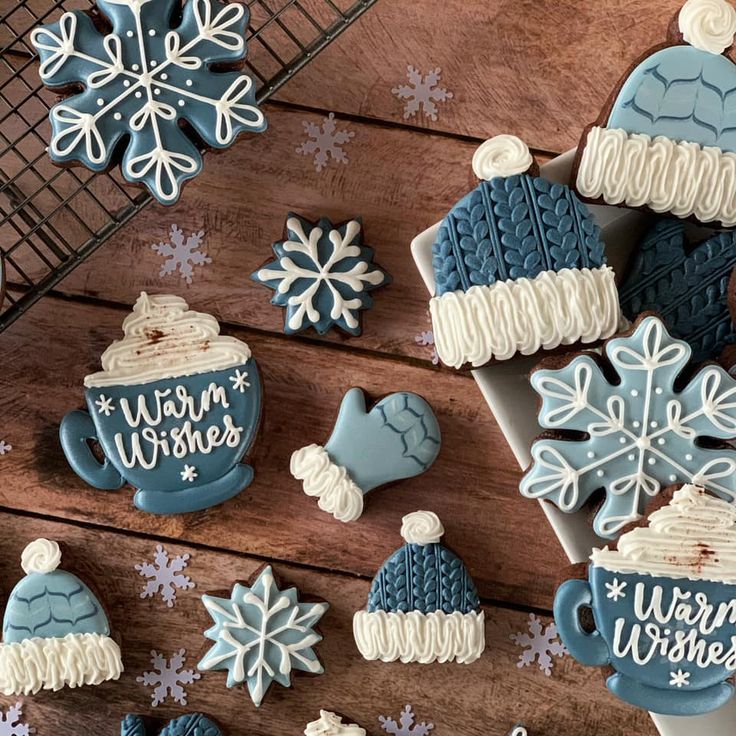 decorated cookies on a wooden table with snowflakes and mittens in the background