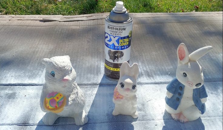 three plastic rabbits sitting on the ground next to a bottle of deodorant