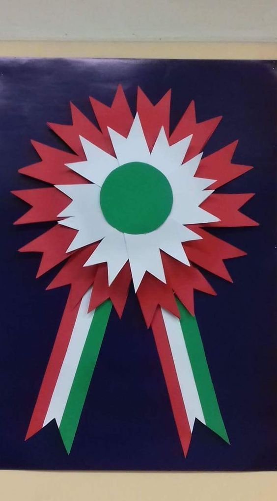 a red, white and green paper flower on a blue background with the center cut out