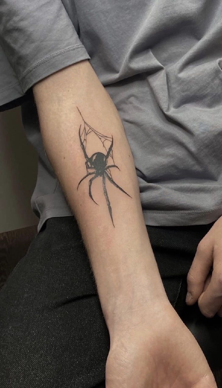 a man with a spider tattoo on his arm