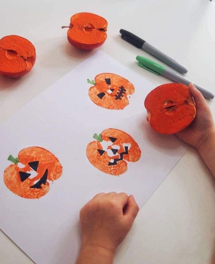 a child is making pumpkin faces out of toilet paper with crayons on the table