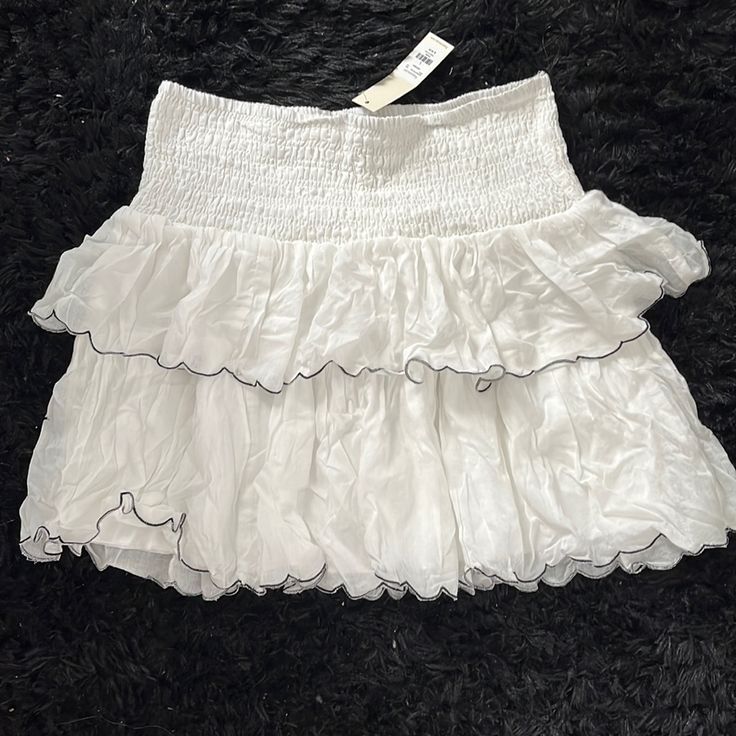 Size Large Never Worn New With Tag White Stretch Tiered Mini Skirt, White Tiered Skort For Spring, White Tiered Mini Skirt With Elastic Waistband, White Stretch Mini Skirt With Ruffles, White Stretch Skort With Ruffles, White Ruffled Mini Bottoms, White Ruffled Bottoms For Spring, White Tiered Mini Skirt With Ruffles, White Mini Skort With Ruffle Hem