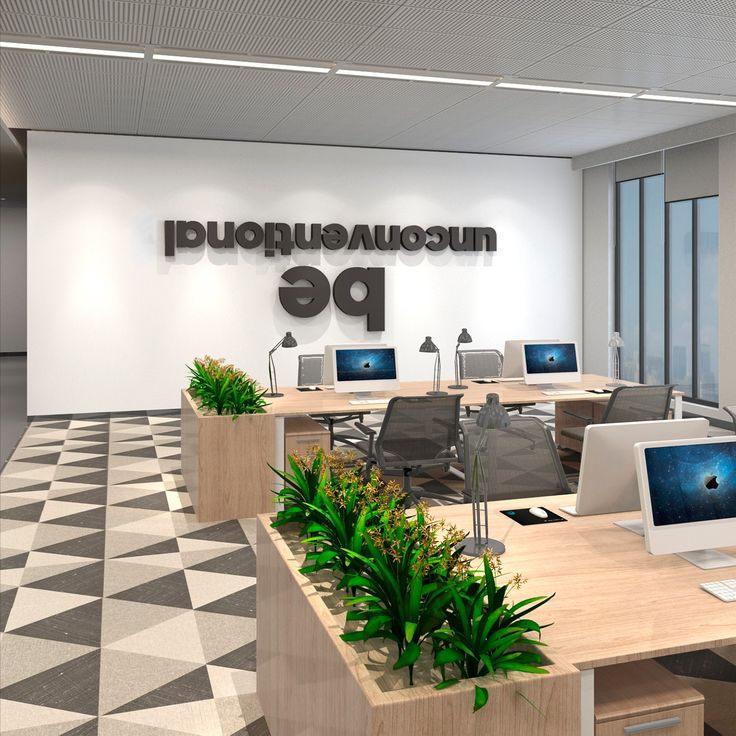 an office with desks, computers and plants in front of the sign that says pe