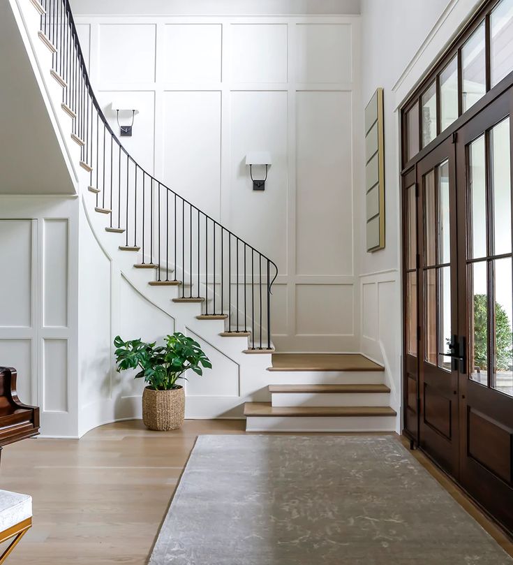 an entryway with stairs, potted plant and chandelier