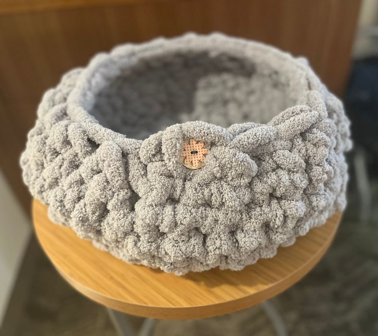 a crocheted basket sitting on top of a wooden table