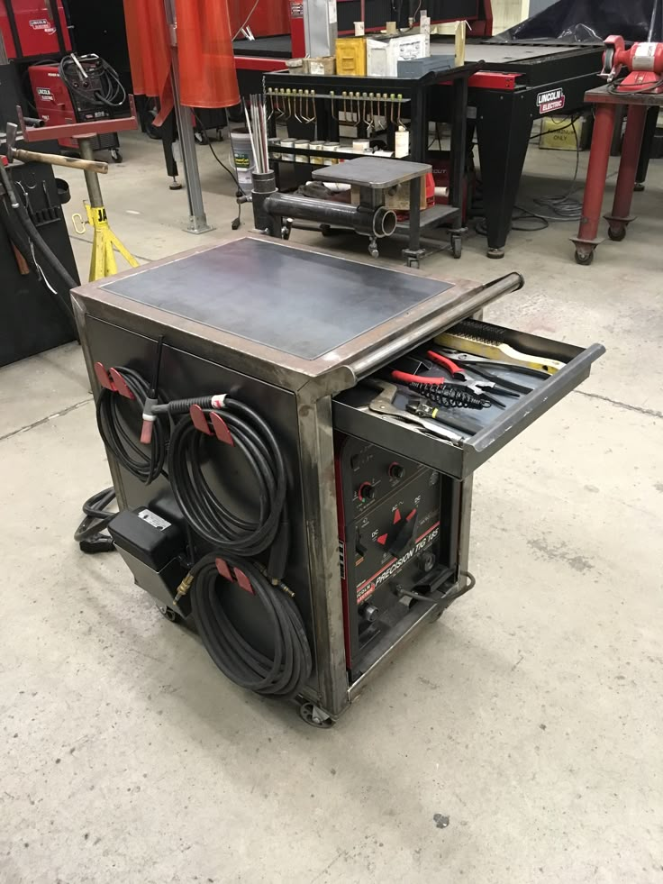 a workbench with many tools in it on the floor next to other equipment