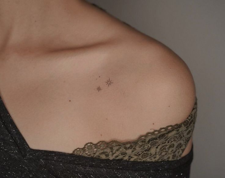 a close up of a woman's shoulder with a star tattoo on her chest