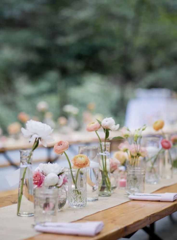 a long table with vases and flowers on it