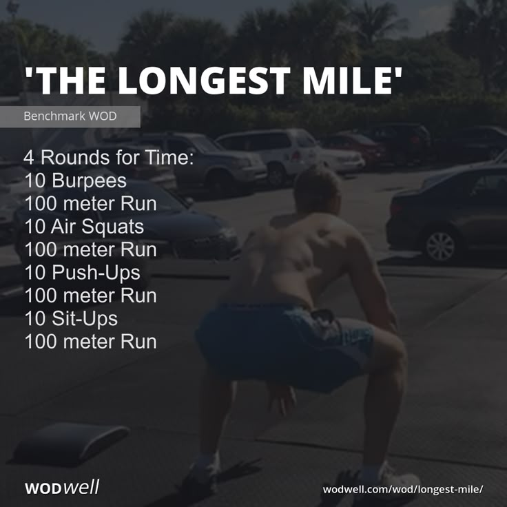 a man is doing squats in the middle of a parking lot with other cars