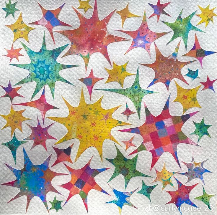 a painting of many different colored stars on a white paper sheet with watercolor paint