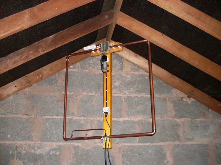 an overhead view of a room with exposed beams and wires on the wall, in front of a brick wall