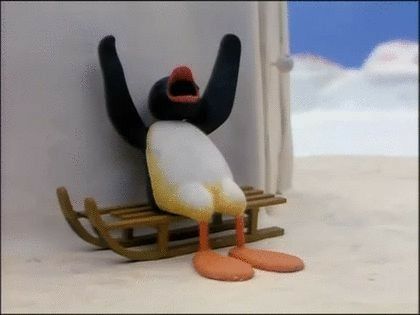 a toy penguin sitting on top of a sled