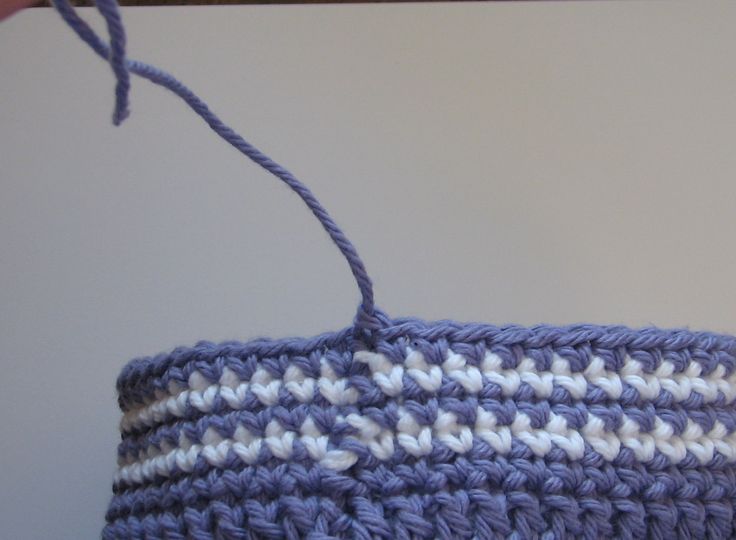 a crocheted basket hanging from a hook