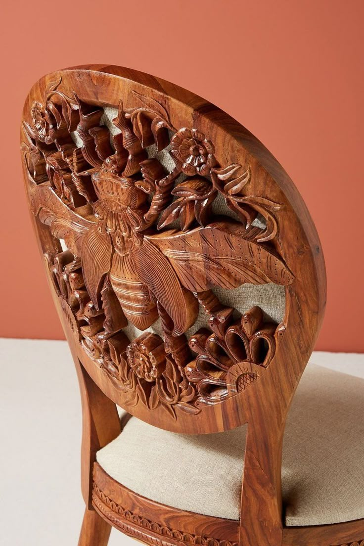 a carved wooden chair with an upholstered seat