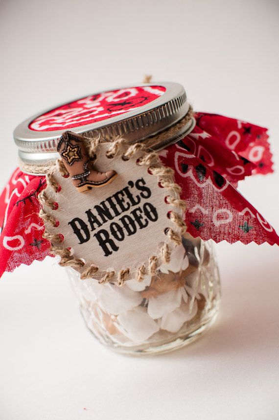 a glass jar filled with white and red candies next to a tag that says daniel's rodeo