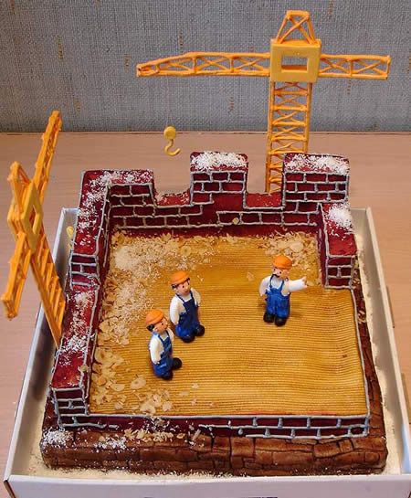 two figurines on top of a cake in the shape of a brick wall