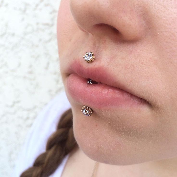 a close up of a person with two piercings on their nose and behind her ear