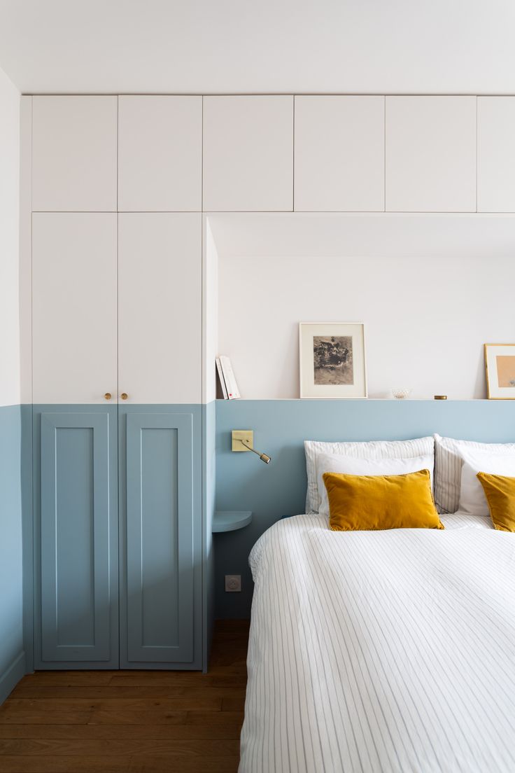 a bed with white and blue walls in a bedroom