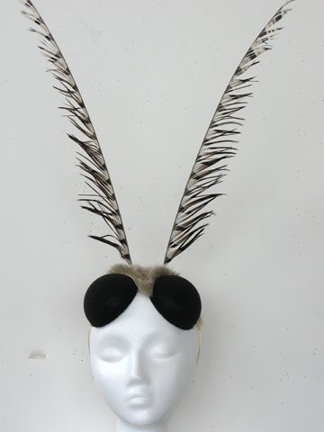 a white mannequin head with feathers and sunglasses on it's headpiece