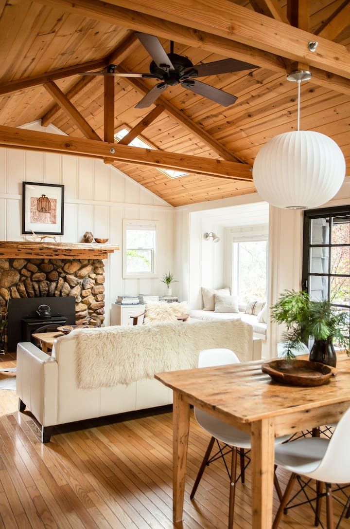 a living room filled with furniture and a fire place next to a wooden dining table