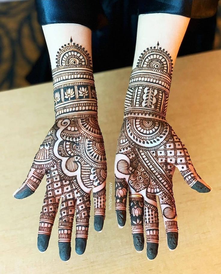 two hands with henna designs on them