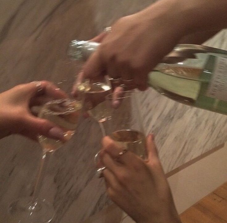 several people are toasting with wine glasses