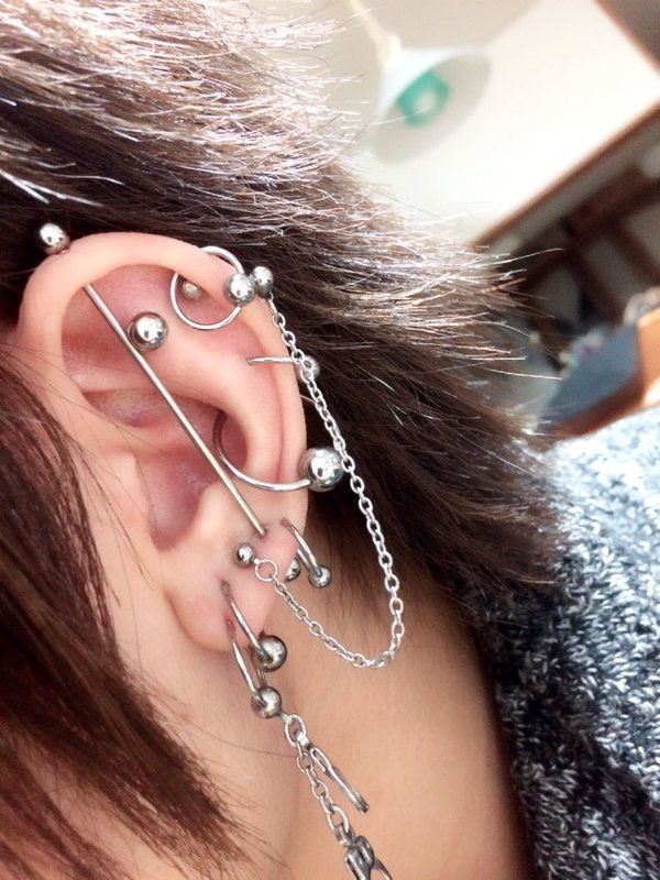 a person with ear piercings and chains on their ears