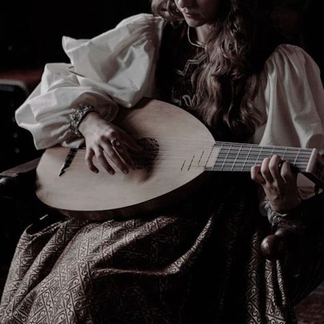 a woman sitting in a chair holding a guitar