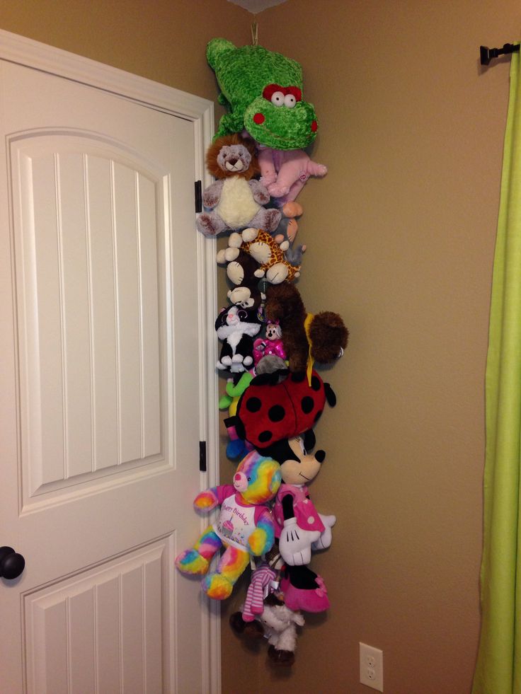 a bunch of stuffed animals are hanging on the wall in front of a white door