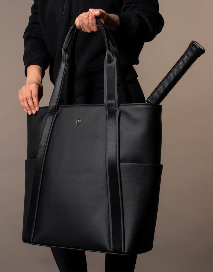 a person holding a black bag with a baseball bat in it's handle and the bottom part of their hand