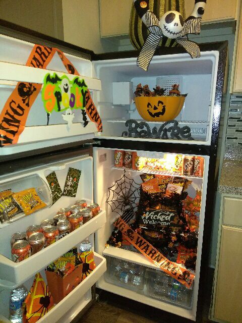 an open refrigerator with halloween decorations and candy