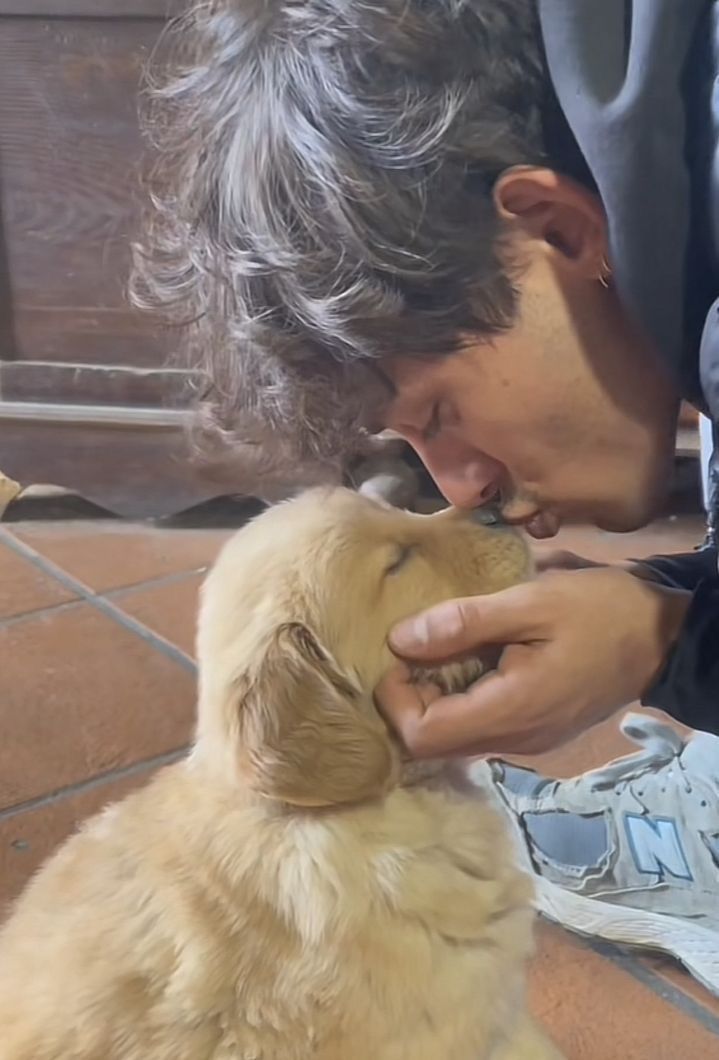 a man is petting a dog on the nose while sitting down with his shoes