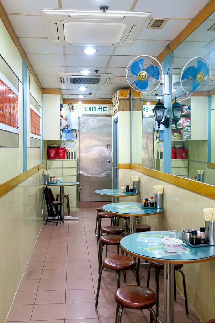 the inside of a restaurant with tables and stools