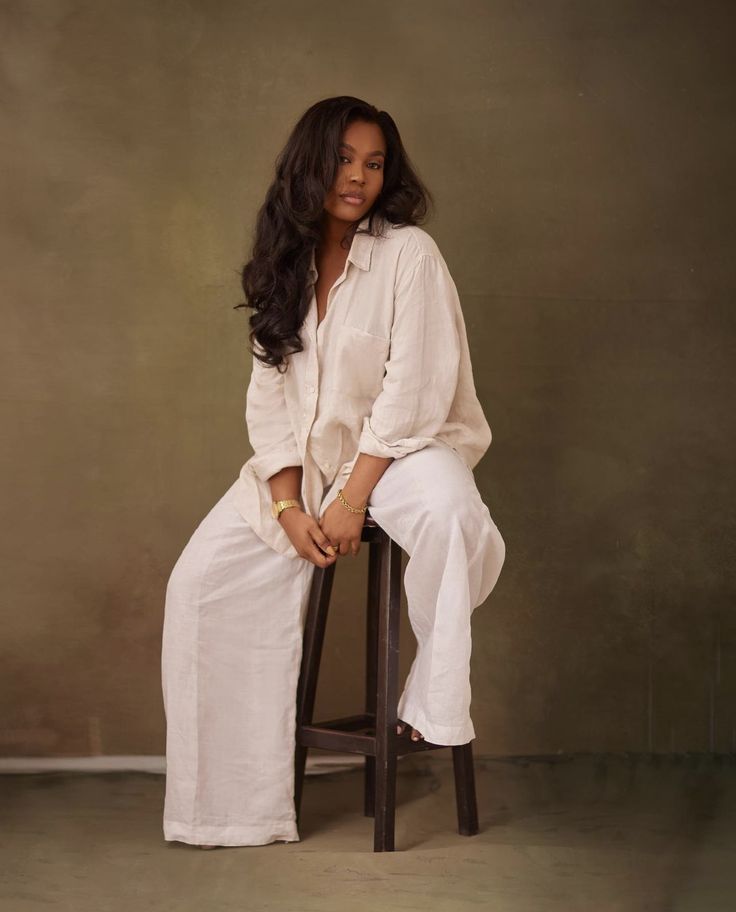 a woman sitting on top of a wooden stool