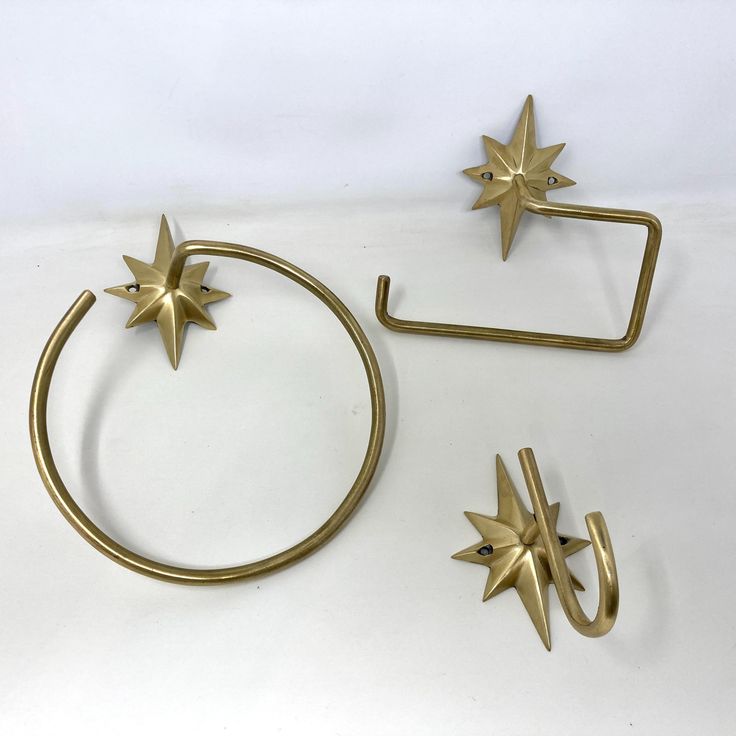 three pieces of brass metal with stars on the top, and one piece is shaped like a circle