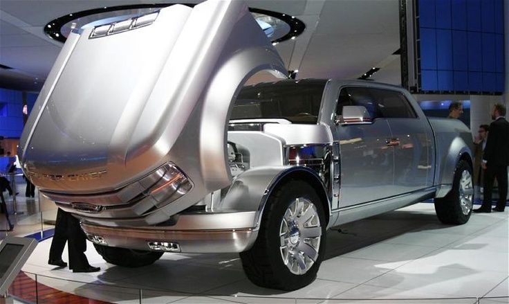 a silver truck is on display in a showroom with people looking at the vehicle