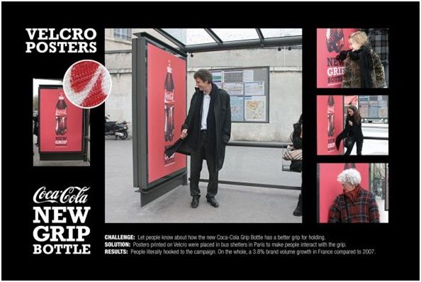 a man standing in front of a coca cola advertisement