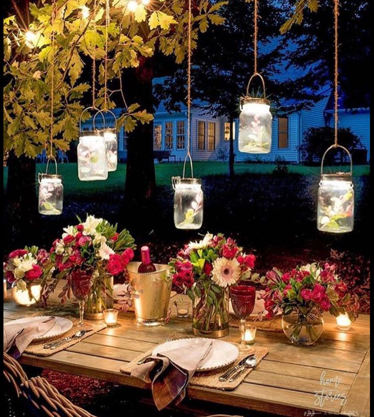 an instagram photo with flowers and mason jars hanging from the ceiling over a table