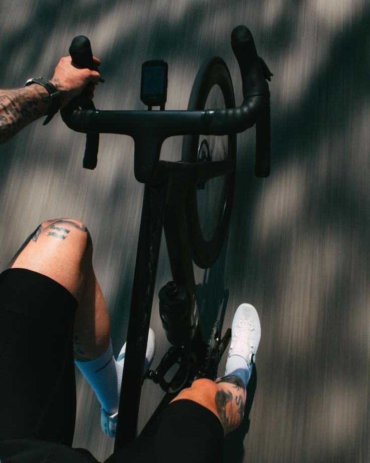 a man riding a bike down a street with his feet on the handlebars