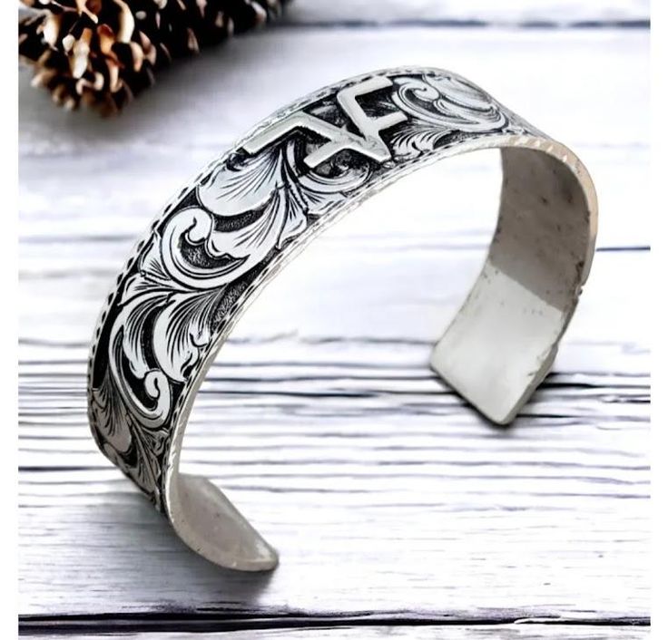 Made upon order; allow 2 weeks for production. Simply lovely, sturdy solid sterling silver cuff, crafted with intricate hand-engraved custom designed scrollwork and delicate borders, this timeless piece adds elegance to any outfit. Perfect as a gift or a treat for yourself. Enhance your style effortlessly.  Material:  .925 sterling silver Size: 5/8" width, choose length from drop-down box.  For brands, send picture to us via Etsy message. To wear: Slide onto side of wrist through opening and rot Bridal Jewelry Silver, Silver Engraving, Simply Lovely, Sterling Silver Cuff, Jewelry Silver, Silver Cuff, Hand Engraving, Gift Wedding, Timeless Pieces