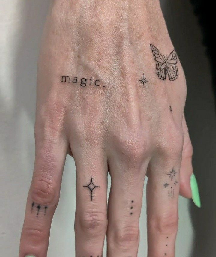 a woman's hand with tattoos on it and the word magic written in black ink