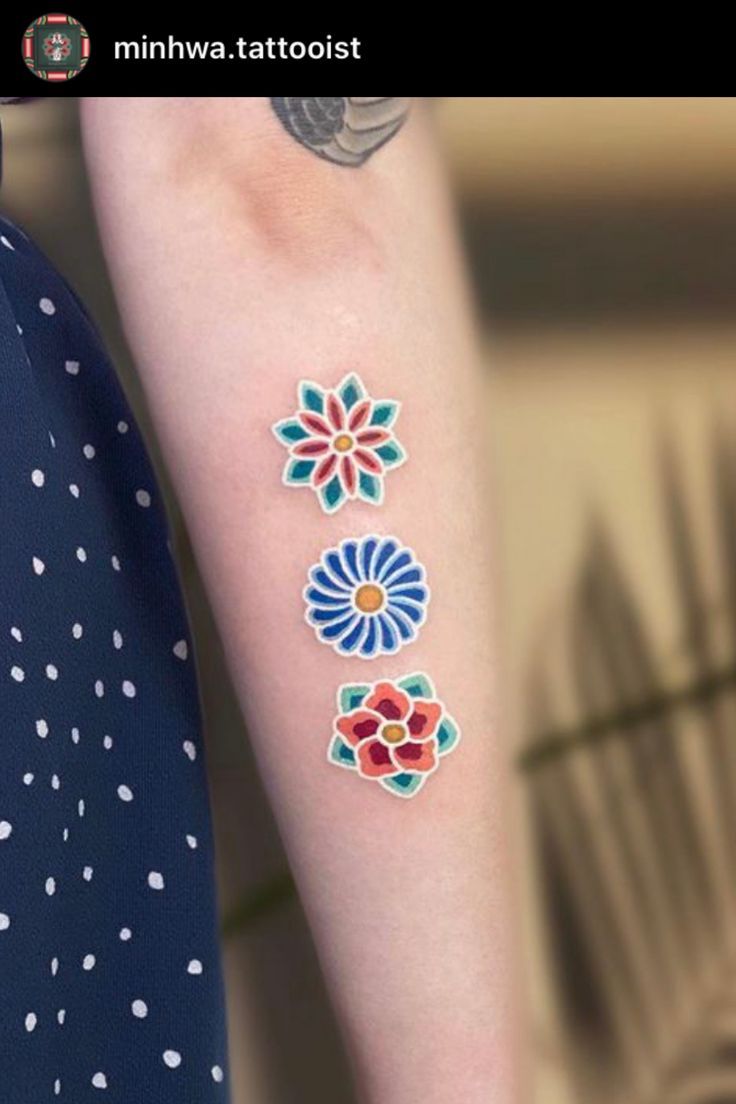 On this pin, there is a traditional Asian tattoo of dancheong flowers, traditional Korean colors, done by Minhwa tattooist on Instagram Traditional Tattoo Meanings, Colorful Flower Tattoo, Korean Tattoo Artist, Cuff Tattoo, Traditional Tattoo Flowers, Korean Colors, Flower Tattoo Drawings, Korean Tattoos, Doll Tattoo