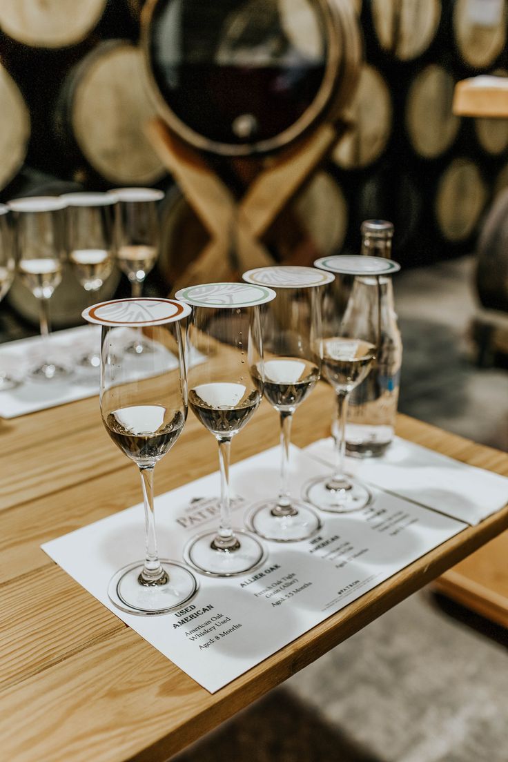 wine glasses sitting on top of a wooden table